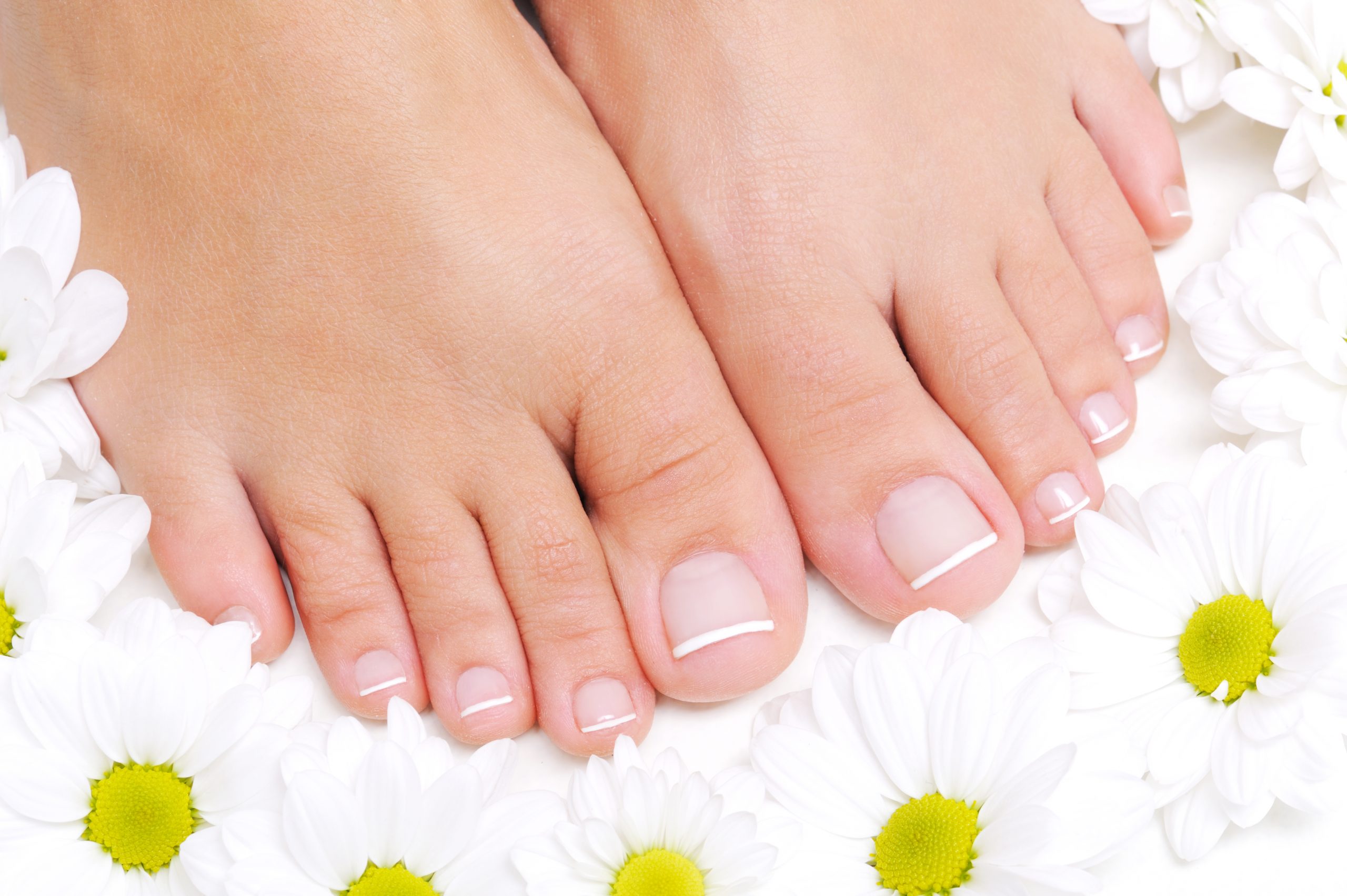 flowers around beautiful female feet with french pedicure scaled 1